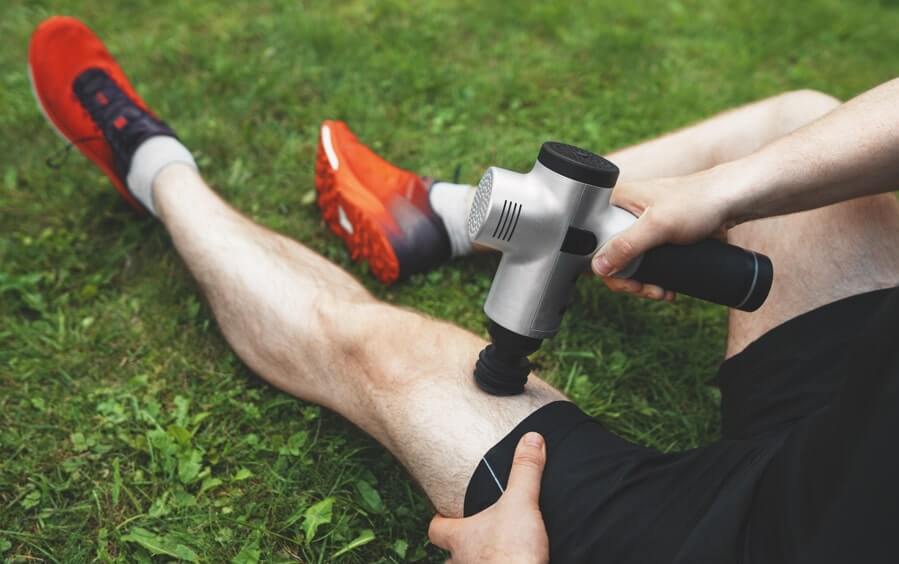 Runner using muscle massager